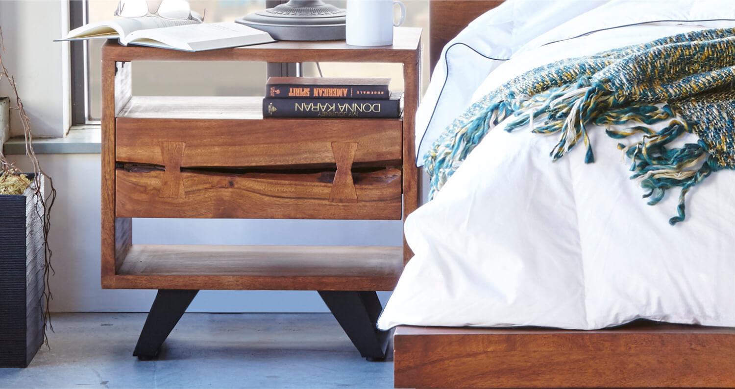 Wooden side table next to bed