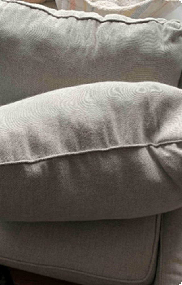 Two light gray pillows are stacked on a sofa, with soft fabric texture and subtle swirl patterns. A green label in the corner reads 'After.'