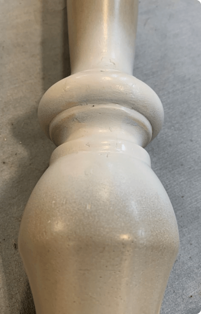A smooth, freshly painted white wooden table leg with a glossy finish is shown on a gray surface. A green 'After' label indicates completion.