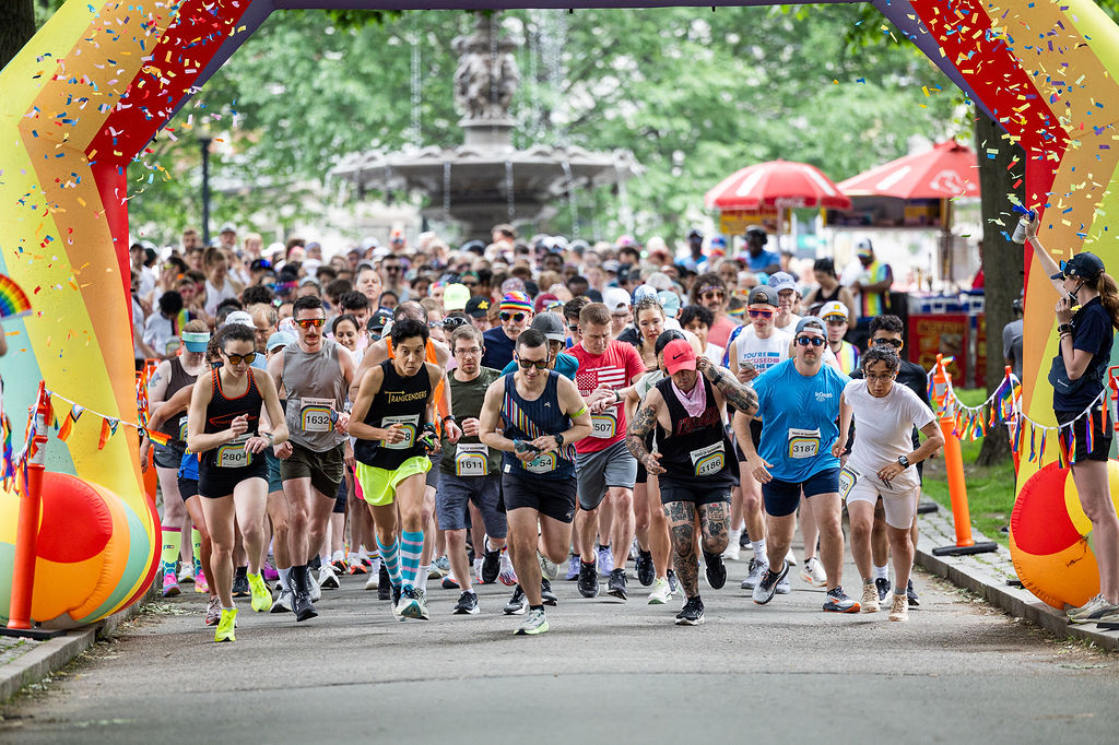 Runners dressed in colorful sports attire begin the Road of Rainbows 5k
